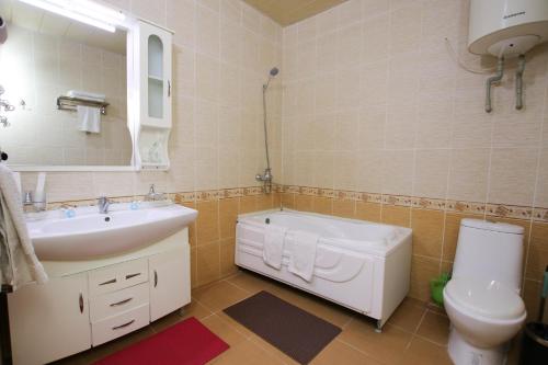 een badkamer met een wastafel, een toilet en een spiegel bij ORIYO DUSHANBE HOTEL in Doesjanbe