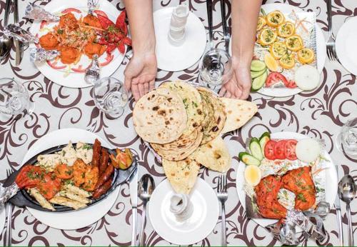 uma mesa com pratos de comida em cima em ORIYO DUSHANBE HOTEL em Dushanbe