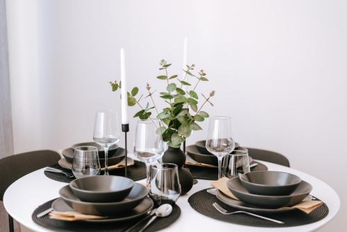 a dining room table with black plates and glasses at Apartman Vista in Daruvar