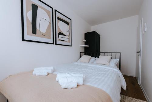 um quarto branco com uma cama com toalhas em Apartman Vista em Daruvar
