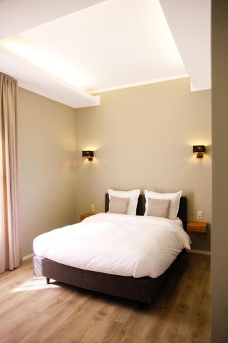 a bedroom with a large white bed with two pillows at Villa les érables Restaurant Linea in Spa