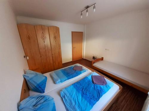a bedroom with two beds with blue sheets at Ferienwohnungen Lend 3 in Lend