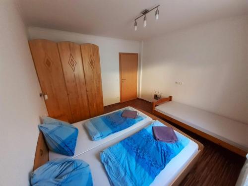 a bedroom with two beds with blue sheets at Ferienwohnungen Lend 3 in Lend
