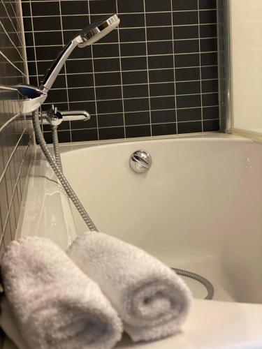 a white bath tub with a faucet and towels at Hotel De Boskar Peer in Peer