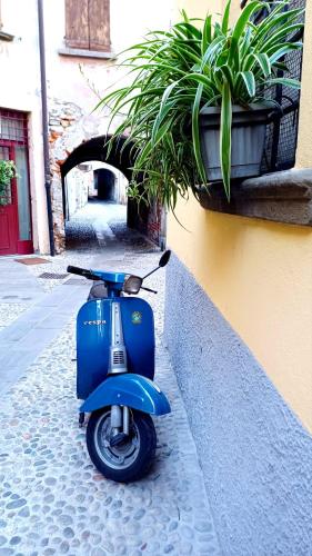 a blue scooter parked on the side of a building at Iseo Portelle Holiday da Barbara - private parking & bike storage in Iseo