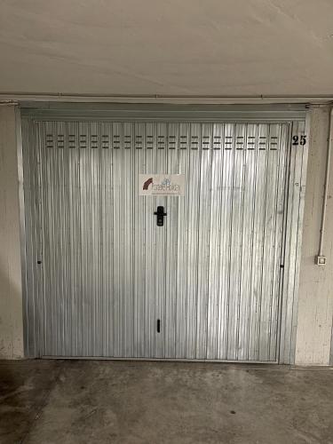 a metal garage door with a sign on it at Iseo Portelle Holiday da Barbara - private parking & bike storage in Iseo