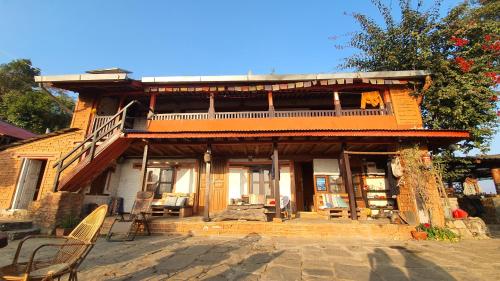 ein großes Holzhaus mit einem Balkon und Stühlen in der Unterkunft Back to Nature in Kāskī