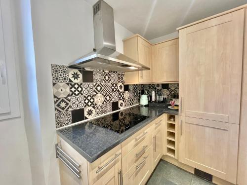 - une cuisine avec des placards en bois et des comptoirs en granit dans l'établissement Carré d'or Duplex, by Welcome to Cannes, à Cannes