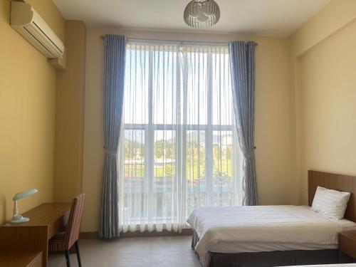 Un dormitorio con dos camas y una gran ventana. en Polaris Hotel, en Kỳ Anh