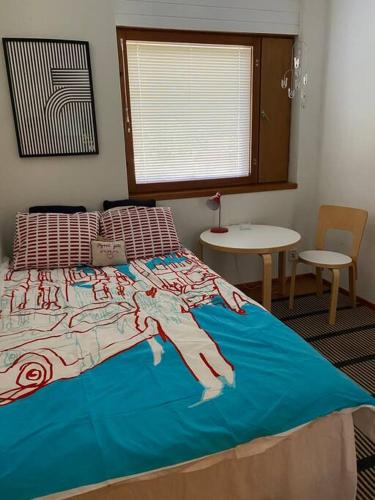 sypialnia z dużym łóżkiem i niebieskim kocem w obiekcie Metsäkoto, laadukas huoneisto Eurassa. w mieście Rauma