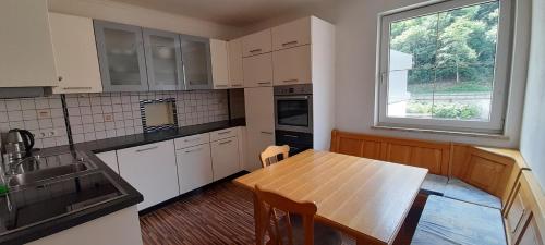 a kitchen with a wooden table and a window at Ferienwohnungen Lend 3 in Lend