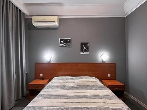 a bedroom with a bed with two nightstands and two lamps at Готель Зірка in Kropyvnytskyi