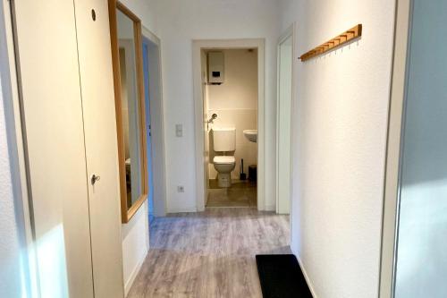 um corredor de uma casa de banho com WC e espelho em Work & stay apartment in Neuss em Neuss