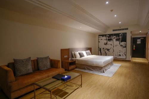 a living room with a bed and a couch at Mirfa Hotel in Al Marfaʼ