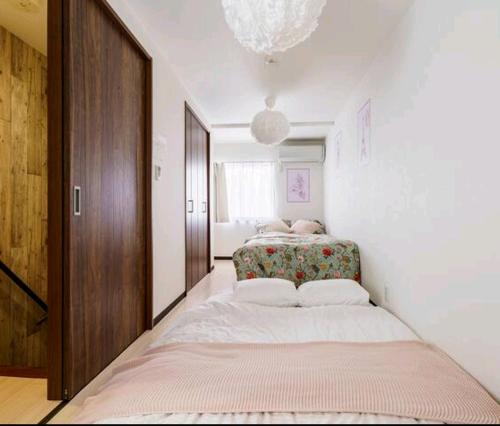 ein Schlafzimmer mit einem großen Bett und einem Kronleuchter in der Unterkunft Healing Inn Osaka Fukushima in Osaka