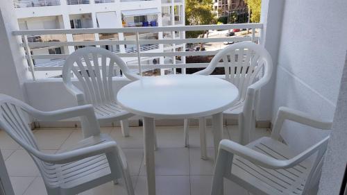 Una mesa blanca y dos sillas en un balcón. en Royal II, en Salou