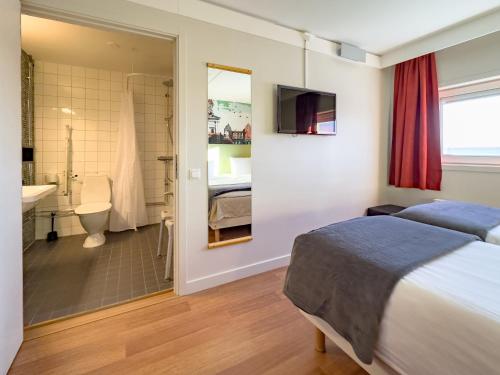 a bedroom with a bed and a bathroom at Good Morning Lund in Lund