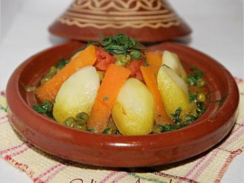 a wooden bowl of food with carrots and potatoes at Camp trip Merzouga in Merzouga