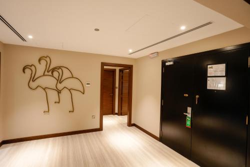 a hallway with two flamingos on the wall at Mirfa Hotel in Al Marfaʼ