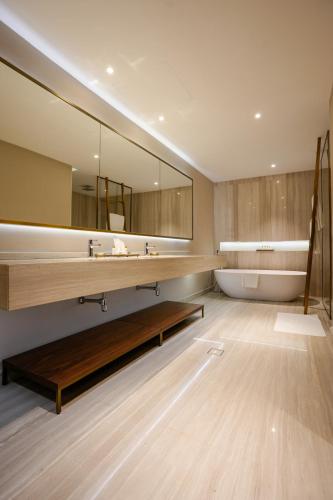 a bathroom with a large mirror and a tub at Mirfa Hotel in Al Marfaʼ