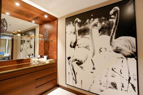 a bathroom with a picture of flamingos on the wall at Mirfa Hotel in Al Marfaʼ