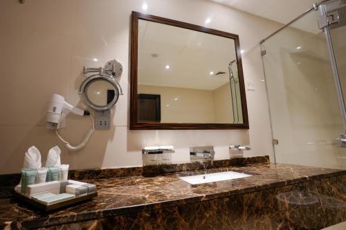 a bathroom with a sink and a mirror at Mirfa Hotel in Al Marfaʼ