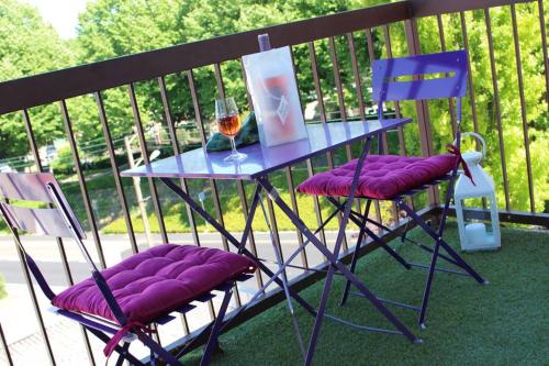 una mesa con 2 sillas y una copa de vino en el balcón en Le Clos Pichot - Studio avec balcon, parking privé - 5mn Gare, en Chartres