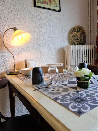 une table avec une lampe au-dessus dans l'établissement Le Clos Pichot - Studio avec balcon, parking privé - 5mn Gare, à Chartres