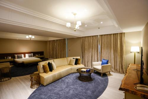 a living room with a couch and a bed at Mirfa Hotel in Al Marfaʼ