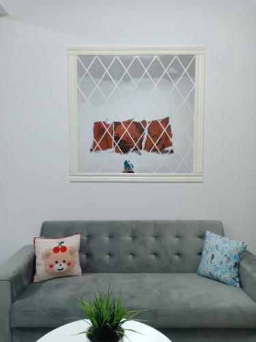 un divano grigio in un soggiorno con una foto sul muro di Nuraz@Adelia2 a Kajang