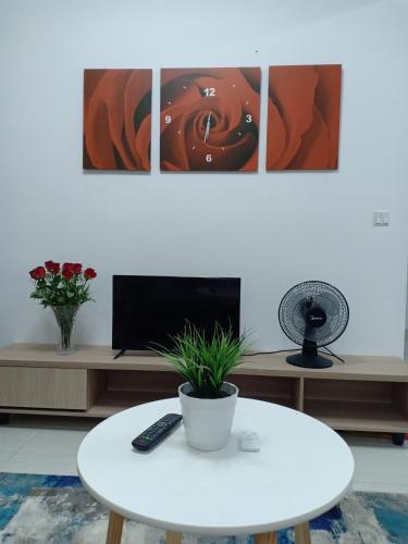 un soggiorno con tavolo bianco e TV di Nuraz@Adelia2 a Kajang