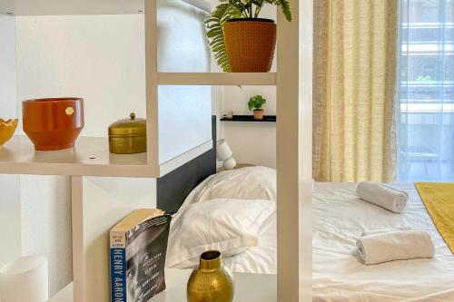 Cette chambre dispose d'étagères blanches, d'un lit et d'une fenêtre. dans l'établissement LE STELLA MARINE Studio AirCo garage for 2 By Sunset, à Juan-les-Pins