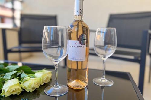 une bouteille de vin et deux verres à vin sur une table dans l'établissement LE STELLA MARINE Studio AirCo garage for 2 By Sunset, à Juan-les-Pins