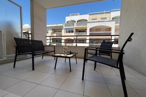 un patio avec deux chaises et une table sur un balcon dans l'établissement LE STELLA MARINE Studio AirCo garage for 2 By Sunset, à Juan-les-Pins