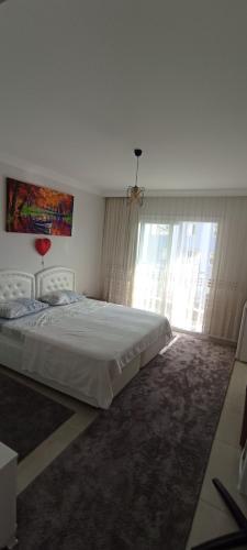 Un dormitorio con una cama grande y una ventana en Sabinanın sıcak evi, en Didim