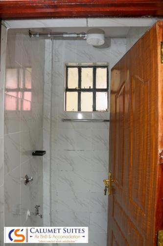 a bathroom with a shower with a window at Calumet Suites Airbnb and Accommodation in Ngong