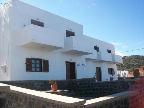 ein weißes Haus mit einer Seitentreppe in der Unterkunft Pali Nisyros Hotel in Páloi