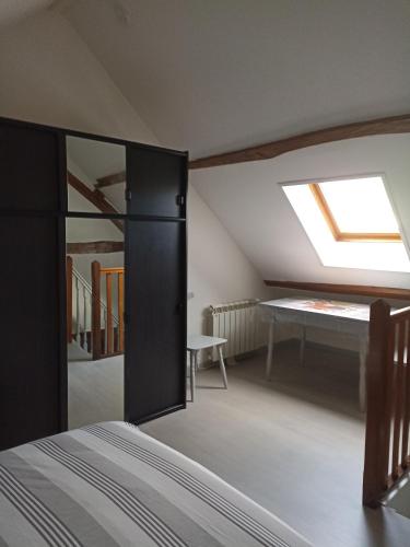 Cette chambre comprend un lit, une fenêtre et une table. dans l'établissement La BenO'Bene, à Estrées-Saint-Denis