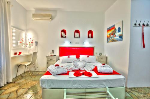 a bedroom with a large bed with a red headboard at Eleni Dream Village in Parikia