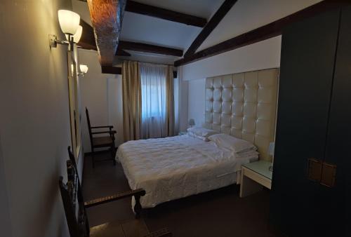 um quarto com uma cama grande e uma janela em Palazzo Eugenia - Minelli em Veneza