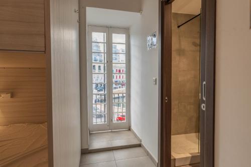 a room with a glass door leading to a bedroom at The Rose Hostel in St Julian's