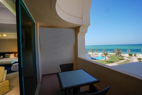 a room with a table and a view of the beach at Mirfa Hotel in Al Marfaʼ