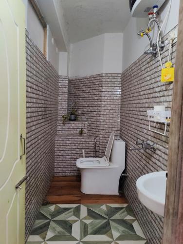 uma casa de banho com um WC e um lavatório. em Ivory Botanic Stay em Darjeeling