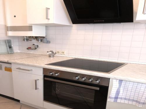 a kitchen with white cabinets and a stove top oven at Fewo Reutlingen Metzstraße in Reutlingen