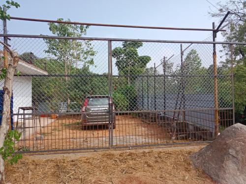 Ein Zaun mit einem Truck auf einem Hof. in der Unterkunft Goud's Home stay in New Hampi