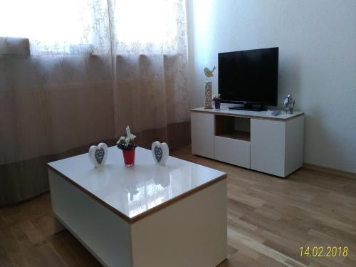 ein Wohnzimmer mit einem TV und einem weißen Couchtisch in der Unterkunft Fewo Reutlingen Metzstraße in Reutlingen