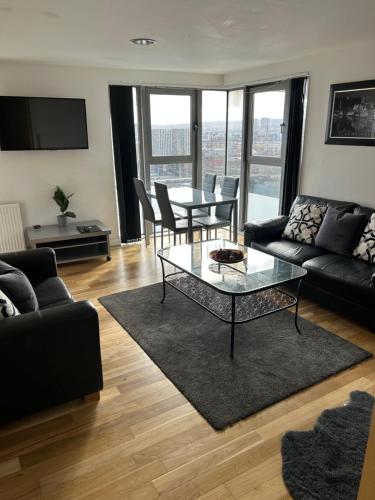 a living room with a couch and a table at Riverside Apartments in Glasgow