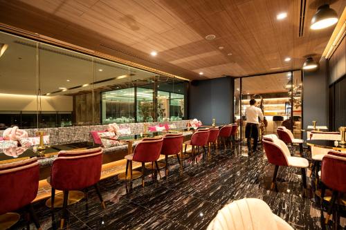 a restaurant with tables and chairs and a man standing in the background at Thaya Hotel Bangkok in Bangkok