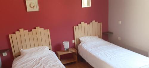 2 łóżka w pokoju z czerwonymi ścianami w obiekcie Chalets à 10 minutes de Foix w mieście Mercus-Garrabet