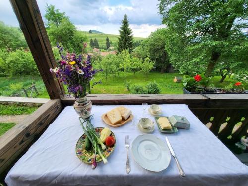 una mesa con un jarrón de flores y un plato de comida en Arboretum Guesthouse, en Şoimeni